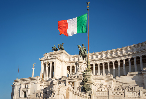 Altare della Patria in Rome and the flag of Italy with a beautiful blue sky